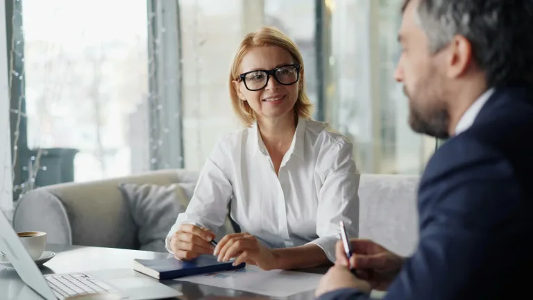 Leadkins.com homepage image showing a woman negotiating with a man during a sales meeting.